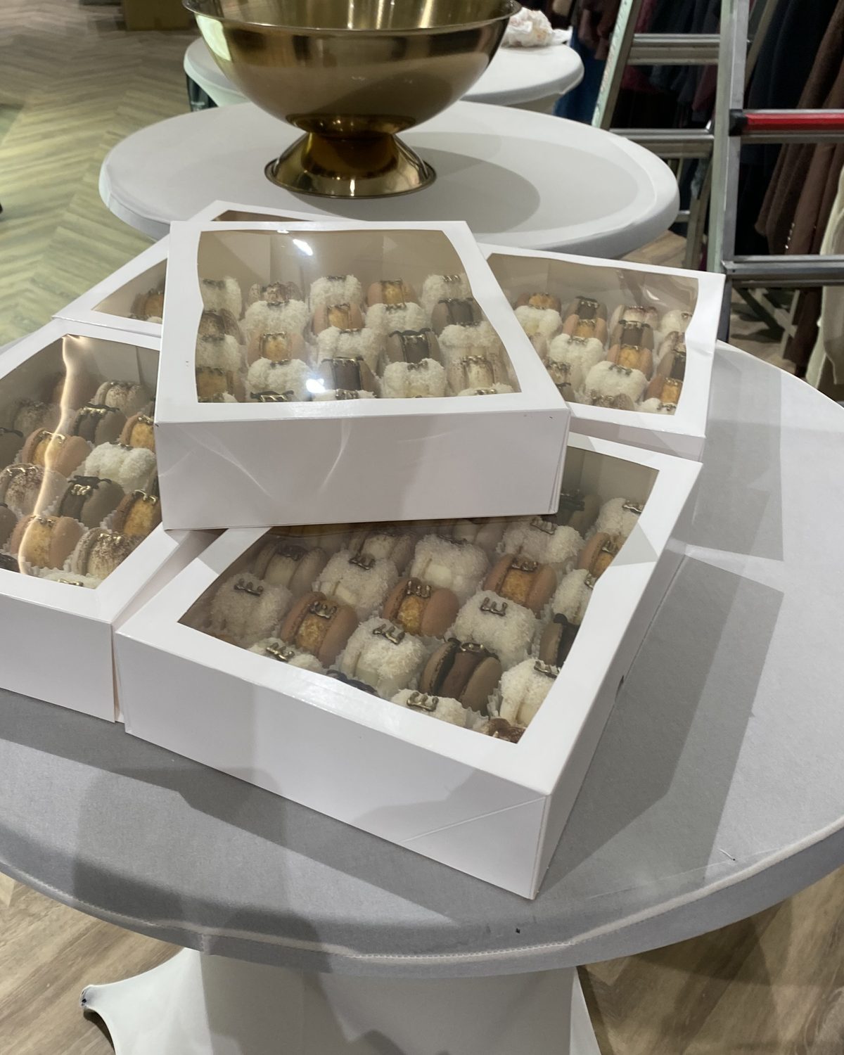 White window boxes of macarons with gold letters on a table inside the Eddy's shop at the opening